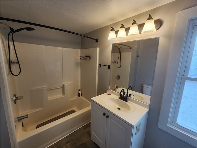 bathroom featuring a textured ceiling, shower / bathing tub combination, and vanity