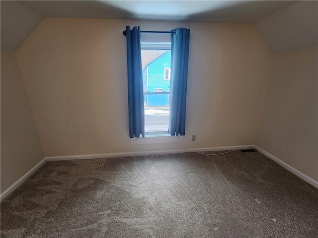 bonus room featuring lofted ceiling, carpet flooring, and baseboards