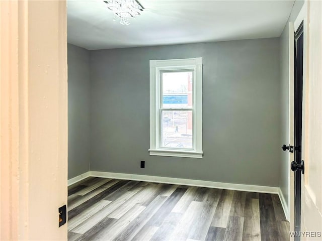 unfurnished room featuring wood finished floors and baseboards