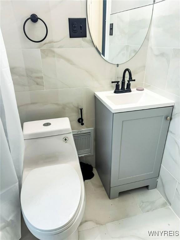 bathroom with marble finish floor, tile walls, visible vents, toilet, and vanity