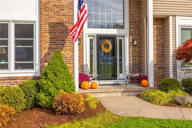 property entrance featuring covered porch and brick siding