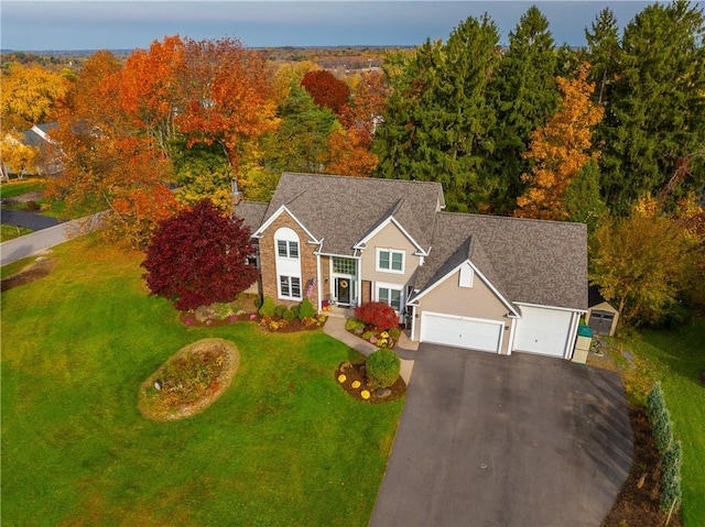 view of front of home with a garage, aphalt driveway, and a front lawn