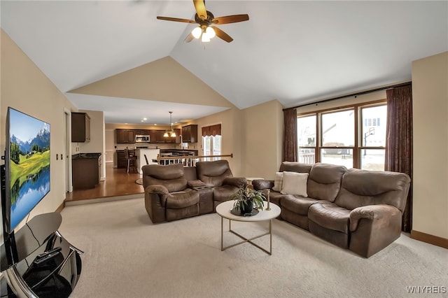 living area featuring light carpet, ceiling fan, and high vaulted ceiling