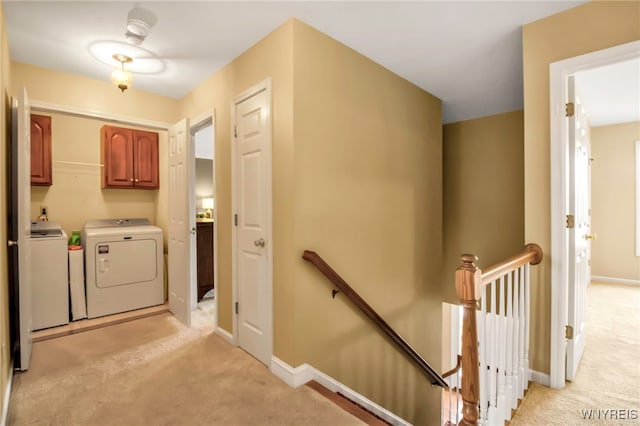 laundry room with light carpet, cabinet space, washing machine and dryer, and baseboards