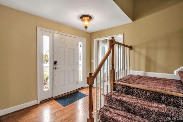 entryway with baseboards, stairway, and hardwood / wood-style floors