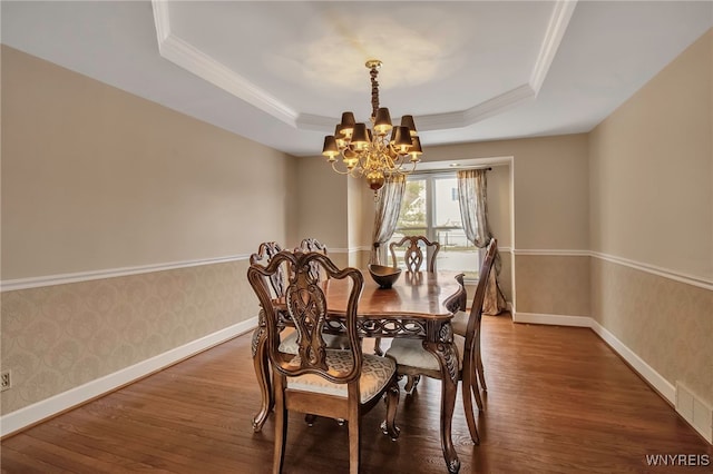 dining space featuring wallpapered walls, baseboards, a raised ceiling, wood-type flooring, and a chandelier