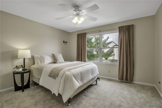 bedroom featuring light carpet, ceiling fan, and baseboards