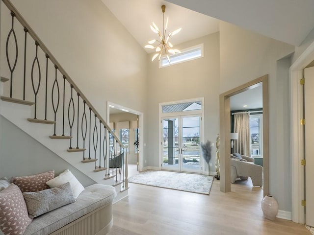 entryway with stairs, baseboards, an inviting chandelier, and wood finished floors