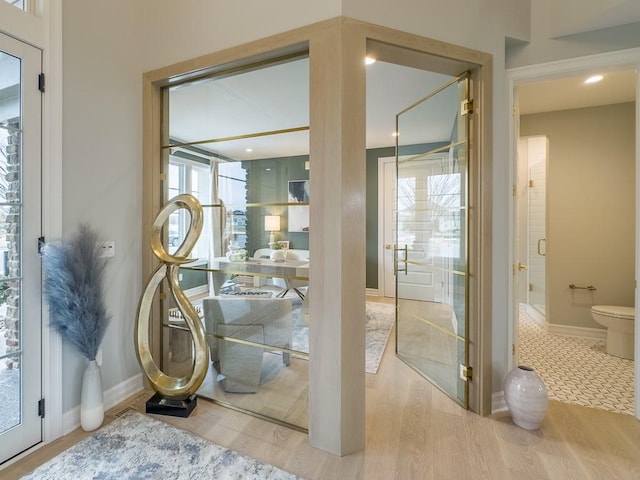 doorway with baseboards and wood finished floors