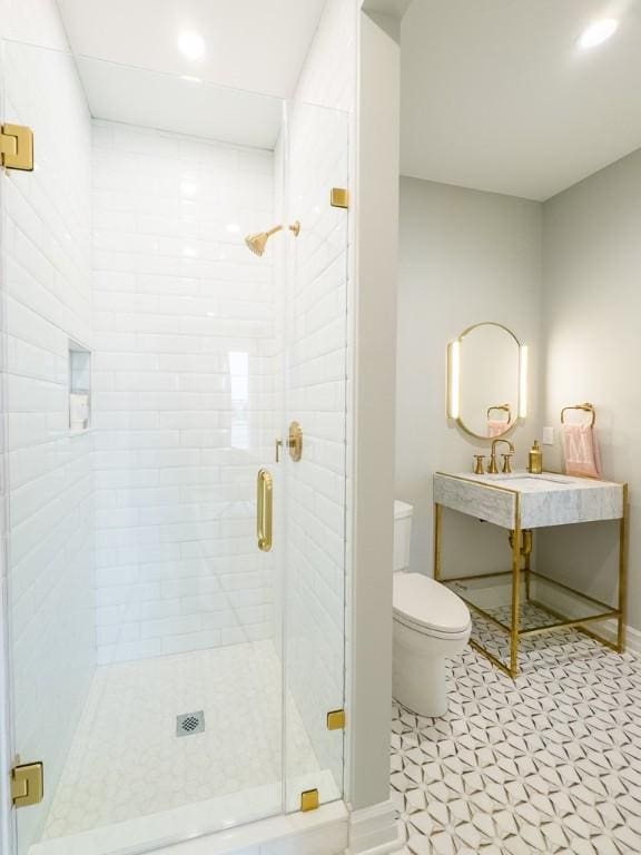 full bathroom with toilet, recessed lighting, a sink, baseboards, and a stall shower