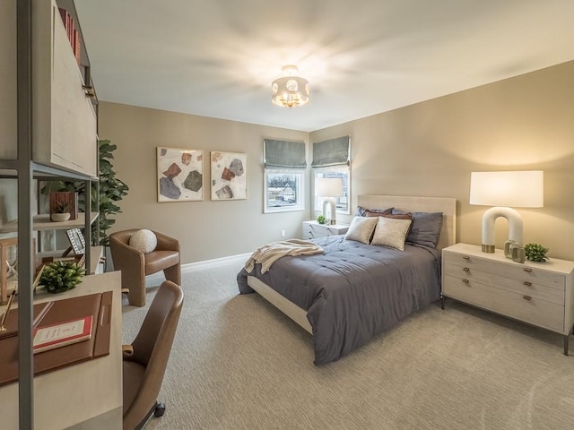 bedroom with baseboards and light colored carpet