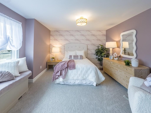 carpeted bedroom with an accent wall and baseboards