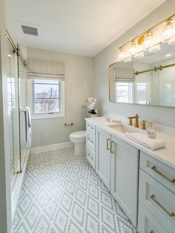 bathroom featuring a stall shower, visible vents, a wealth of natural light, and vanity