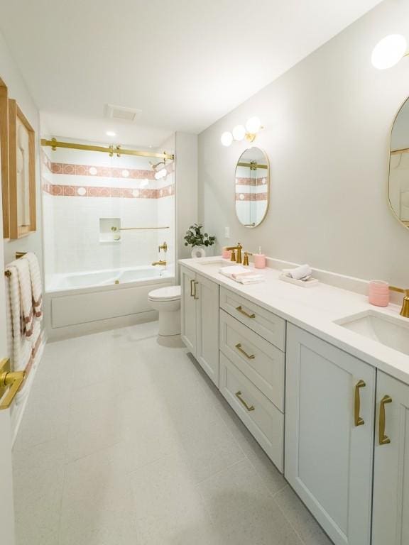 bathroom with double vanity, tub / shower combination, a sink, and toilet