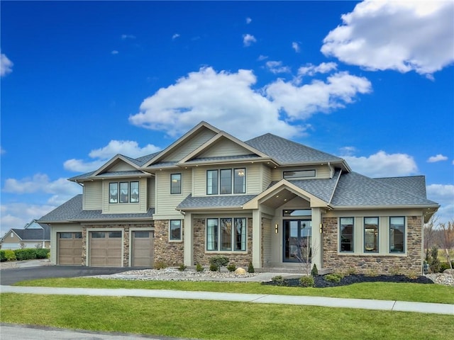 craftsman inspired home featuring stone siding, a front yard, roof with shingles, and a garage