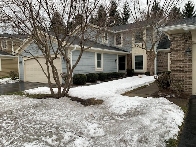 exterior space featuring driveway, a garage, and brick siding