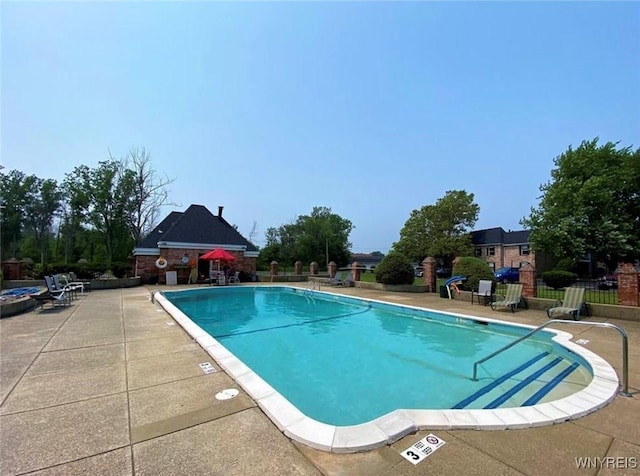 pool featuring a patio area and fence