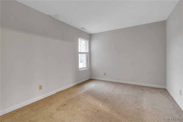 empty room with light carpet, visible vents, and baseboards