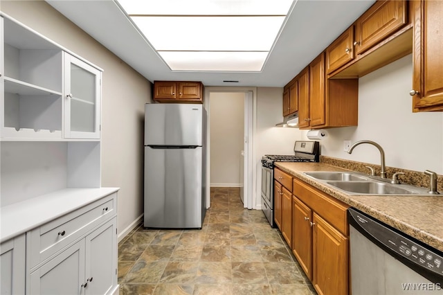 kitchen with under cabinet range hood, a sink, baseboards, appliances with stainless steel finishes, and brown cabinetry