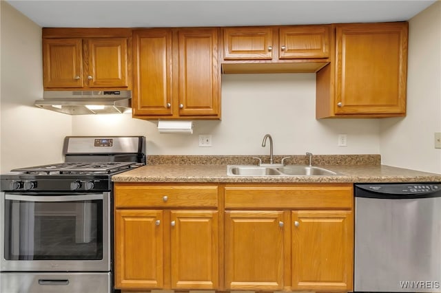 kitchen featuring stainless steel appliances, brown cabinetry, a sink, and under cabinet range hood