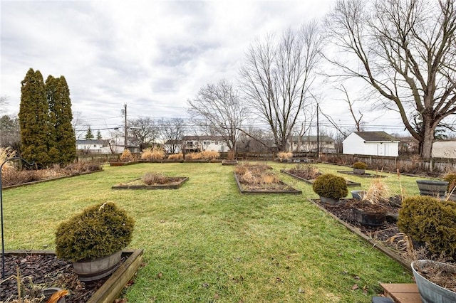 view of yard featuring fence and a vegetable garden