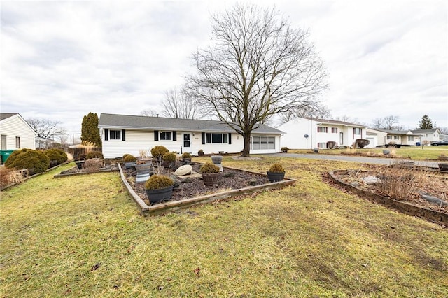 rear view of property featuring a garage, a yard, and driveway