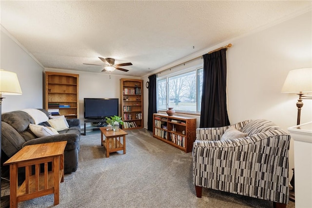 living room with a textured ceiling, ceiling fan, ornamental molding, and carpet