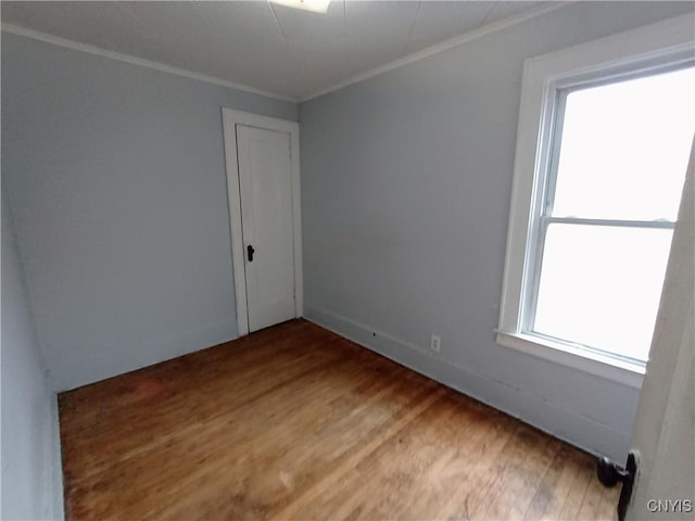 unfurnished room with crown molding and wood finished floors