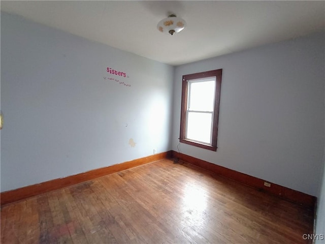 empty room featuring hardwood / wood-style floors and baseboards