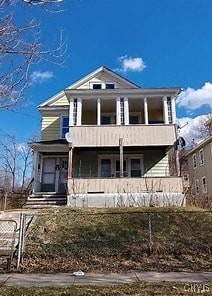 view of front facade with a fenced front yard and a balcony