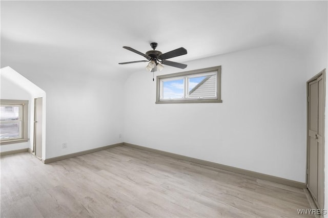 interior space with light wood-type flooring, baseboards, a ceiling fan, and lofted ceiling