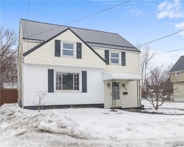 view of front of home featuring metal roof and fence