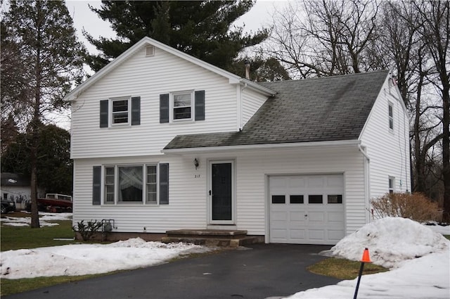 view of front of property featuring driveway, roof with shingles, and an attached garage