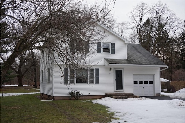 view of front of property featuring a shingled roof, a yard, and an attached garage