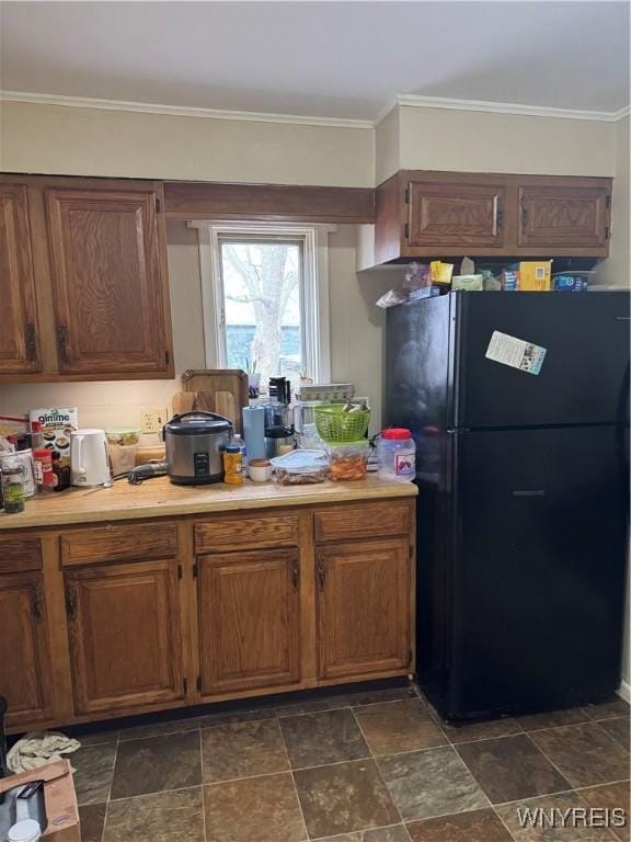 kitchen featuring ornamental molding, freestanding refrigerator, and light countertops