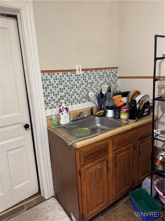 kitchen with light countertops, tile patterned flooring, and a sink