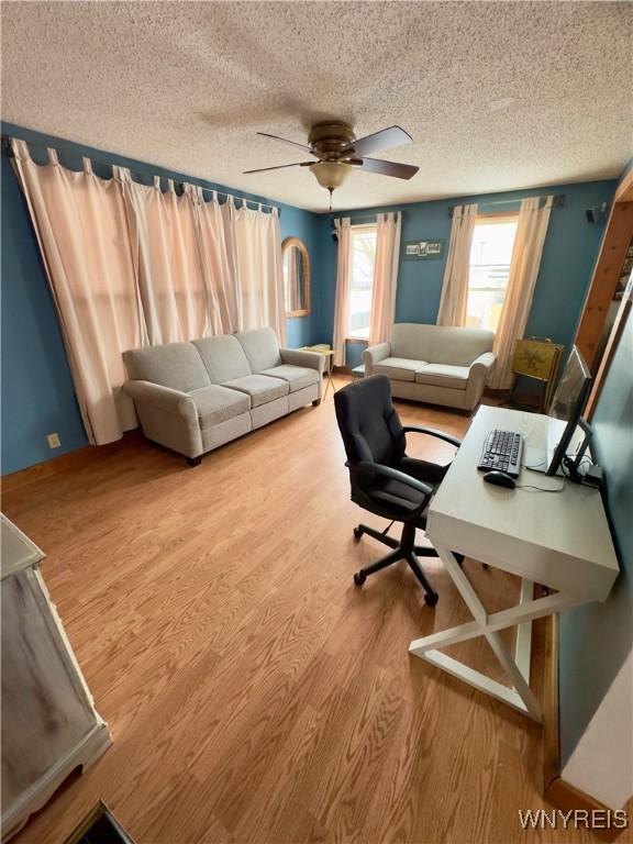 office space with ceiling fan, a textured ceiling, and wood finished floors