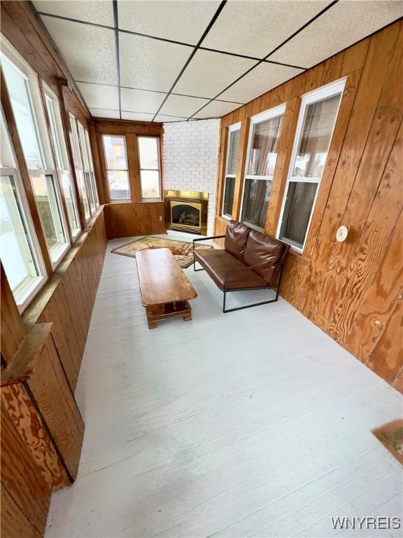 unfurnished sunroom with a drop ceiling and a fireplace