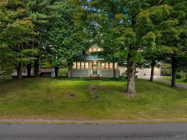 view of property hidden behind natural elements featuring a front yard