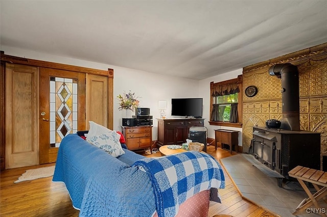 living area with a wood stove and wood finished floors