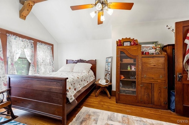 bedroom featuring ceiling fan, lofted ceiling with beams, and wood finished floors