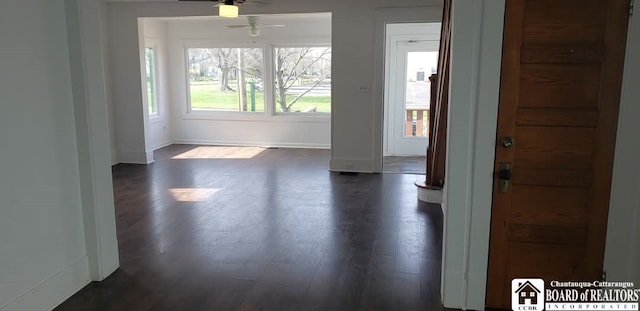 foyer entrance featuring dark wood-style flooring, a ceiling fan, and baseboards