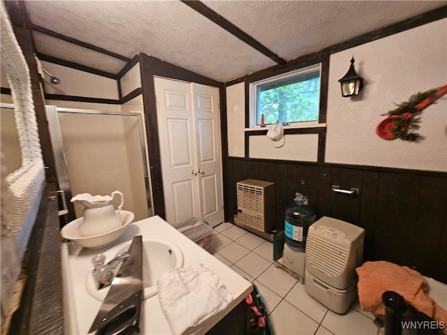 full bathroom with tile patterned flooring, a shower stall, lofted ceiling, wainscoting, and a textured ceiling