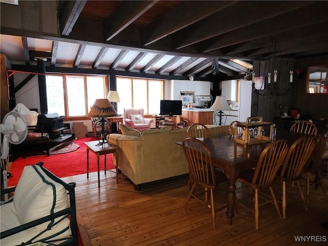 dining area with vaulted ceiling with beams and light wood-style floors