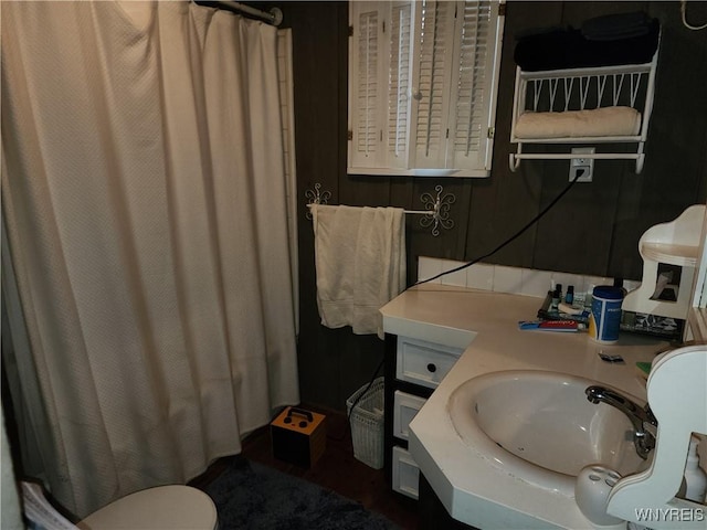 bathroom featuring a sink, curtained shower, and toilet