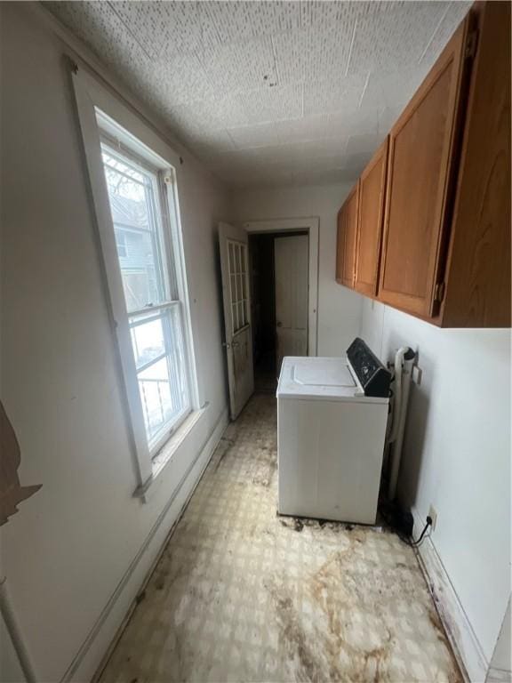 washroom with washer / clothes dryer, cabinet space, and light floors