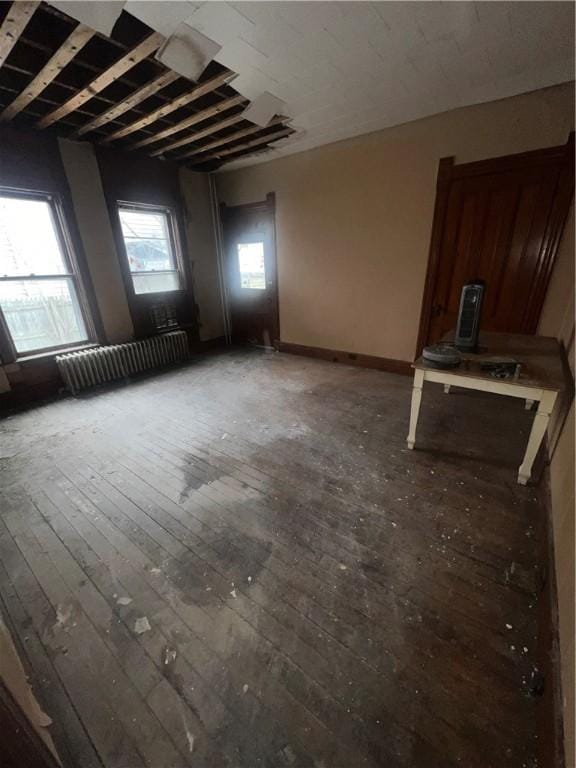 interior space featuring radiator heating unit, wood-type flooring, and baseboards