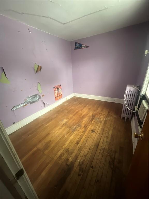 spare room featuring baseboards and hardwood / wood-style floors