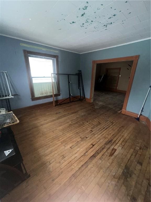 spare room featuring wood-type flooring and ornamental molding