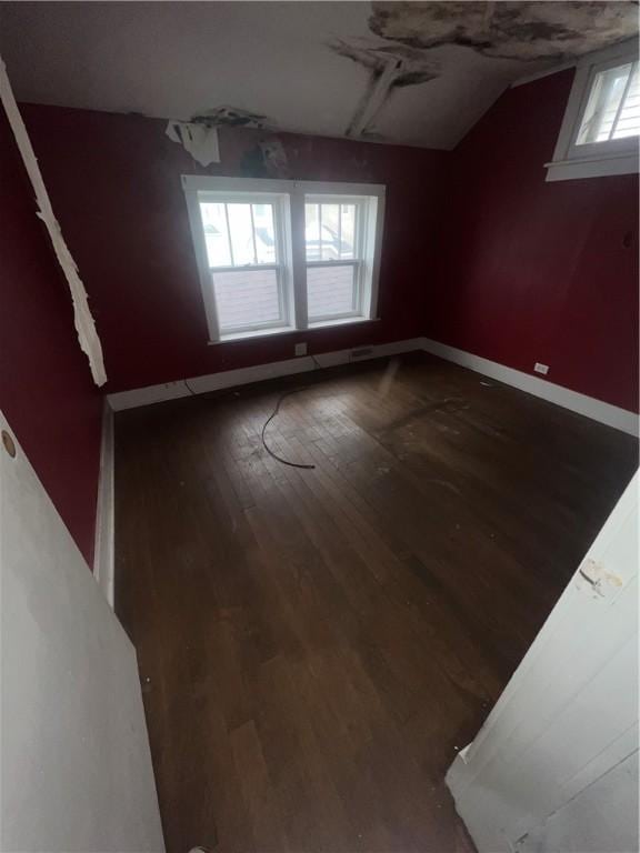 unfurnished room featuring vaulted ceiling, baseboards, and dark wood finished floors